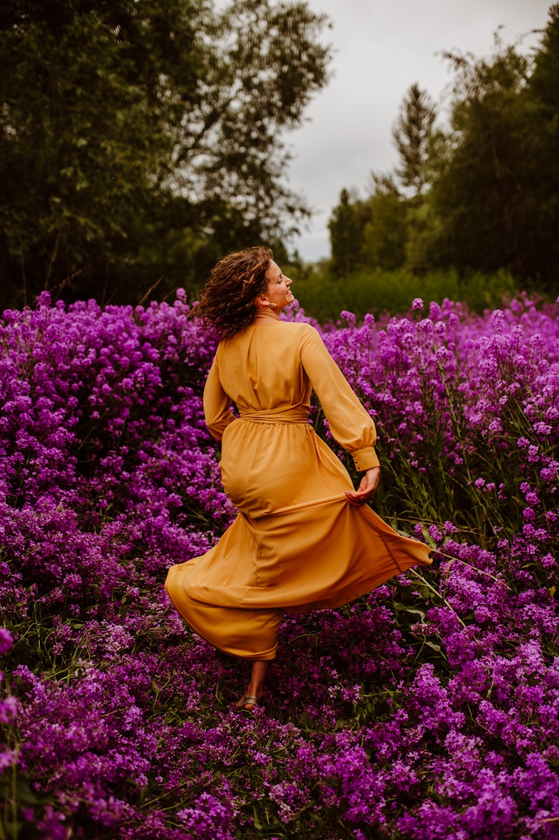 Photo by Amie Roussel A woman in a yellow dress in a field of purple flowers